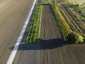 Aerial view of a tractor working in an agricultural field at sunset near Aquileia, Udine, Friuli Venezia Giulia, Italy Royalty Free Stock Photo