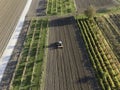 Aerial view of a tractor working in an agricultural field at sunset near Aquileia, Udine, Friuli Venezia Giulia, Italy Royalty Free Stock Photo