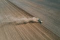 Aerial view the tractor is working in the field creating dust clouds. Spring work in the field. Photo from the drone Royalty Free Stock Photo