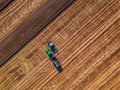 Aerial view of 2 tractors working on the harvest field