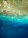 Aerial view of traditional outrigger type boats with snorkelers and swimmers over a tropical coral reef in a clear, warm ocean Royalty Free Stock Photo