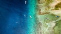 Aerial view of traditional outrigger type boats with snorkelers and swimmers over a tropical coral reef in a clear, warm ocean Royalty Free Stock Photo