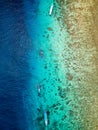 Aerial view of traditional outrigger type boats with snorkelers and swimmers over a tropical coral reef in a clear, warm ocean Royalty Free Stock Photo
