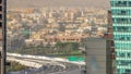 Aerial view of traffic on overpass and many apartment houses in Dubai city from above timelapse.