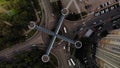 Aerial view of traffic on roundabout with nice architecture pedestrian crosswalk above intersection look like cross