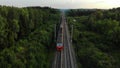 Aerial view: train at the rural scene in summer. The train rides through the rural countryside in the sunrise.