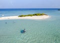 Aerial view of travelers arriving at a small sandy island in the Indian Ocean by motor boat