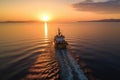 aerial view of trawler navigating through sea at dusk, with sun setting Royalty Free Stock Photo