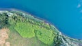 Aerial view of the trees in the woods and the beach and the blue water, beautiful clear sea water on a warm sunny day Royalty Free Stock Photo