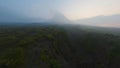 Aerial view tropical forest dirt road canyon frozen volcanic lava smoke eruption