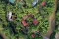 Aerial view of a tropical hotel or lodge located in the jungle and surrounded by lush green foliageand a small brown colored river