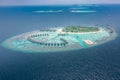 Aerial view of a tropical island in turquoise water. Luxurious over-water villas on tropical island resort maldives