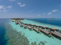 Aerial view of a tropical island in turquoise water. Luxurious over-water villas on tropical island resort maldives.