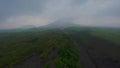 Aerial view tropical jungle forest canyon frozen volcanic lava smoke eruption active volcano