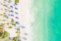 Aerial view of tropical sandy beach with palms and umbrellas at sunny day. Summer holiday on Indian Ocean, Zanzibar, Africa. Royalty Free Stock Photo
