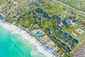 Aerial view of tropical sandy beach with palms and umbrellas at sunny day. Summer holiday on Indian Ocean, Zanzibar, Africa. Royalty Free Stock Photo