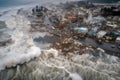 aerial view of tsunami hitting coastal city, with boats and buildings swept away by the rushing water