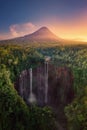 Aerial view of Tumpak Sewu waterfall and Semeru mountain at sunrise located in east java, Lumajang, Indonesia. Natural landscape