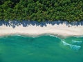 Aerial view on turquoise ocean water with clean empty sand beach and forest