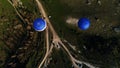 Aerial view of two blue hot air balloons flying above rural roads and green trees and fields. Shot. Flying in the sky Royalty Free Stock Photo