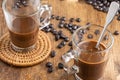 Aerial view of two glass cups with coffee on wooden table with coffee beans and brown sugar, selective focus, Royalty Free Stock Photo