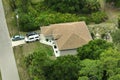Aerial view of typical contemporary american private house with roof top covered with asphalt shingles and green lawn on