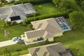 Aerial view of typical contemporary american private house with roof top covered with asphalt shingles and green lawn on