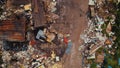Aerial view of an unorganized messy garbage dump with pieces of furniture and big metal rusty containers.