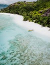 A aerial view of untouched sandy beach with palm trees and lonely tourist boat in blues clear lagoon on Therese Island Royalty Free Stock Photo