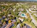 Aerial view of upscale residential area, gated community street real estate with single family homes. Autumn sunny day