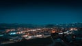 Aerial view of a cityscape at night, with long exposure lights, a starry sky, and mountain tops Royalty Free Stock Photo
