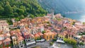 Aerial view of Varenna, Lake Como, Italy. Flying over orange roofs of old town with the church of San Giorgio in the Royalty Free Stock Photo