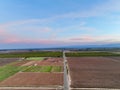 Aerial view of vast, barren fields beneath a splendid blue sky