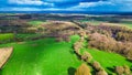 Aerial view of a vibrant rural landscape with lush green fields, patches of forests, and a clear view extending to the horizon Royalty Free Stock Photo