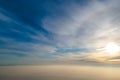 Aerial view of vibrant yellow sunrise over white dense clouds with blue sky overhead Royalty Free Stock Photo