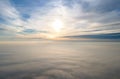 Aerial view of vibrant yellow sunrise over white dense clouds with blue sky overhead Royalty Free Stock Photo