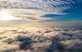 Aerial view of vibrant yellow sunrise over white dense clouds with blue sky overhead Royalty Free Stock Photo