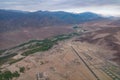 Aerial view of village settlement with airport runway in valley surrounded by mountains Royalty Free Stock Photo