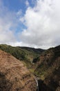 An aerial view of Waimea Canyon with two waterfalls in the distance and with large cumulus clouds in Kauai Royalty Free Stock Photo