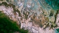 Aerial view of waves break on rocky beach. Sea waves on the beautiful colorful rocky beach. Aerial view drone 4k shot. Zoom in Royalty Free Stock Photo