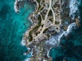 Aerial view of waves crashing on Punta Sur - Isla Mujeres, Mexico - with brilliant blue water, crashing waves and rocky shoreline.