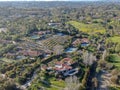 Aerial view of wealthy countryside area with luxury villas with swimming pool, surrounded by forest and mountain valley