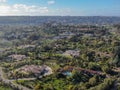 Aerial view of wealthy countryside area with luxury villas with swimming pool, surrounded by forest and mountain valley