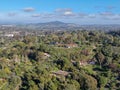 Aerial view of wealthy countryside area with luxury villas with swimming pool, surrounded by forest and mountain valley