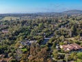 Aerial view of wealthy countryside area with luxury villas with swimming pool, surrounded by forest and mountain valley