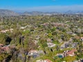 Aerial view of wealthy countryside area with luxury villas with swimming pool, surrounded by forest and mountain valley