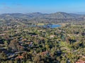 Aerial view of wealthy countryside area with luxury villas with swimming pool, surrounded by forest and mountain valley