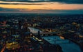 Aerial view of west London, blue hour just after sunset, orange yellow street lights starting to glow, river Thames separating two Royalty Free Stock Photo