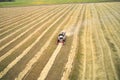 Aerial view of a wheat field and a small combine harvester collecting previously mown ears. Copy space