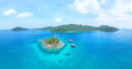 Aerial view of white boats sailing on the crystal blue waters of a picturesque tropical island Royalty Free Stock Photo